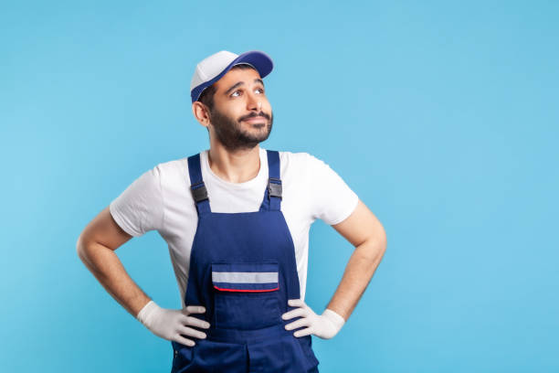 istock Thoughtful handyman in overalls looking up, dreaming with happy inspired expression, making wish. Profession of service industry 1278743944
