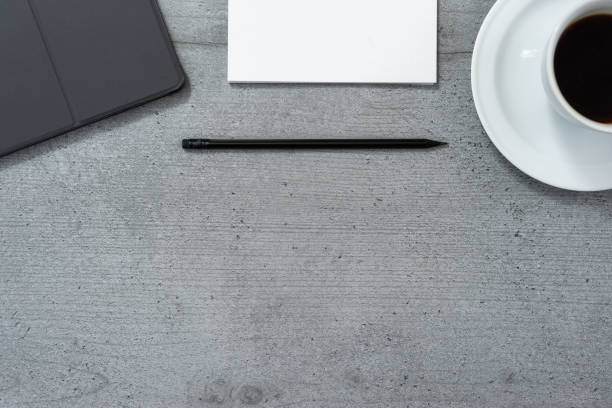 istock Flat lay of office space with a view of a tablet with a gray case, a notebook with a pencil and a cup of coffee. 1278746096