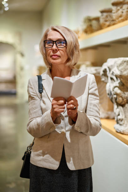 istock Woman Holding a Guide Inside a Museum 1278746266