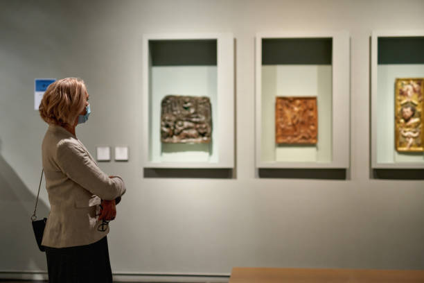 istock woman stading in a room looking and pointing at the empty frames displayed 1278747263