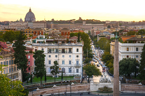 Rome, Italy, September 29 -- A sunset view of Piazza del Popolo and the historic center of Rome from the Pincio Gardens viewpoint, in the Villa Borghese. On the horizon the silhouette of the St. Peter's Basilica dome and a portion of the historic center of Rome and the Campo Marzio district. Villa Borghese its the iconic green heart of Rome where citizens and tourists come to spend hours of relaxation and silence among avenues, ponds and gardens immersed in the green of ancient trees. Image in High Definition format.