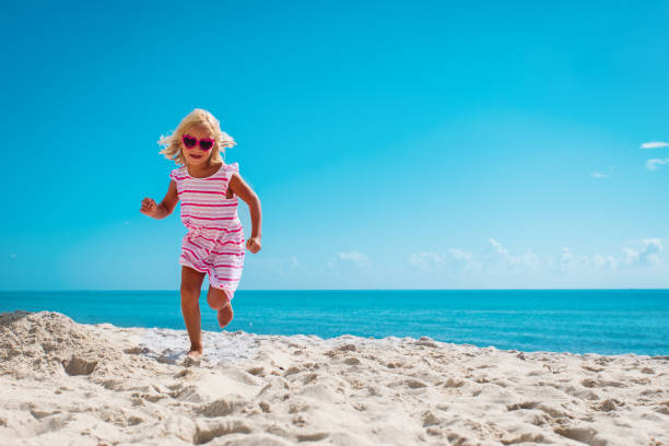 istock cute happy little girl running on beach 1278755193