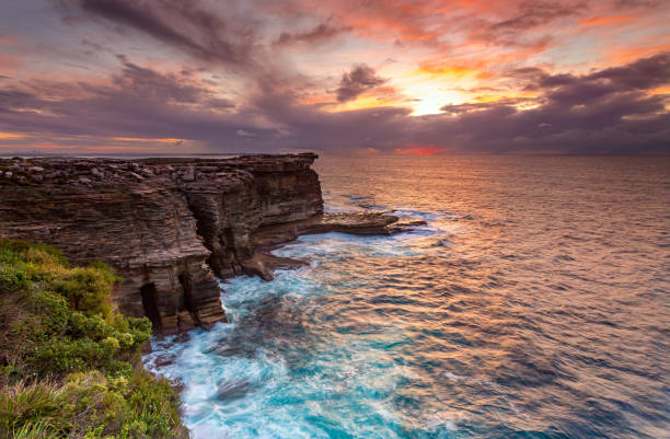 istock Sunrise over the ocean and the crumbling headland cliffs 1278756179