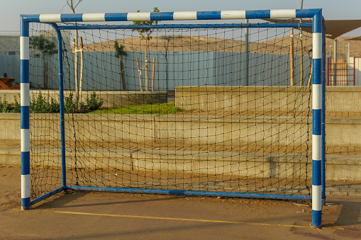 White and blue striped mini football gate with black net