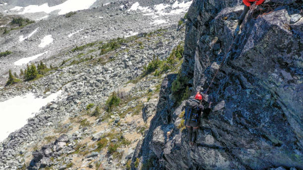 istock Female mountaineer climbs up mountain ridge 1278757854