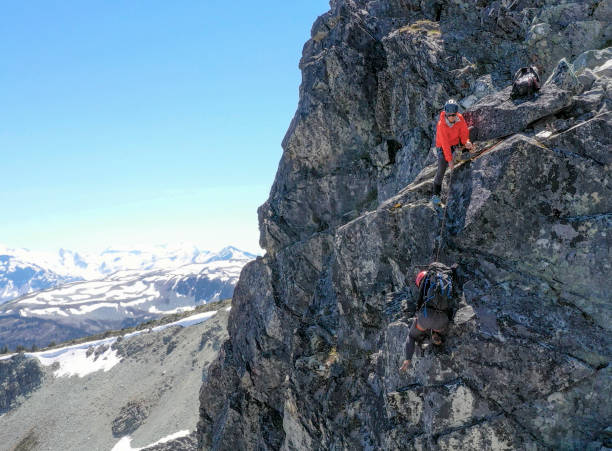 istock Female mountaineer climbs up mountain ridge 1278757889