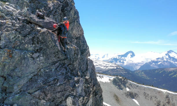 istock Female mountaineer climbs up mountain ridge 1278758016