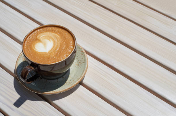 istock Appetizing mug with coffee on a wooden table in a summer restaurant 1278759135