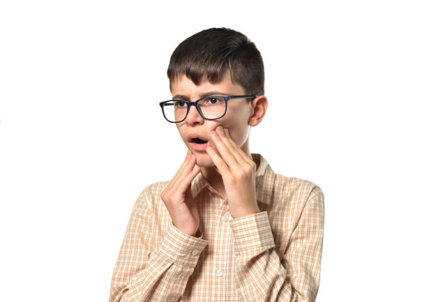 istock Boy on a white background touches his jaw he has a toothache 1278759471