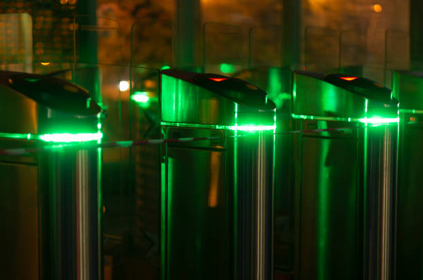 Night scene with three turnstiles with green led lighting without people at the station