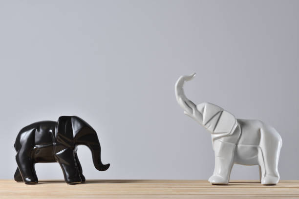 istock Statues of white and black elephants in geometry style 1278760333