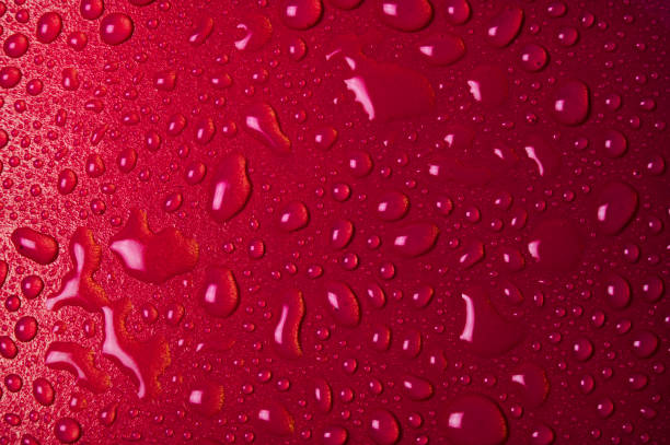 istock Drops of water on a red glass texture background 1278766525