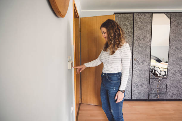istock Woman controlling the heating on the thermostat 1278767062