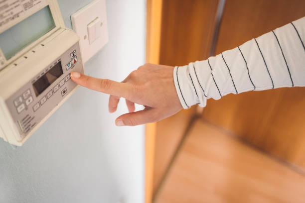 istock Woman controlling the heating on the thermostat 1278767065