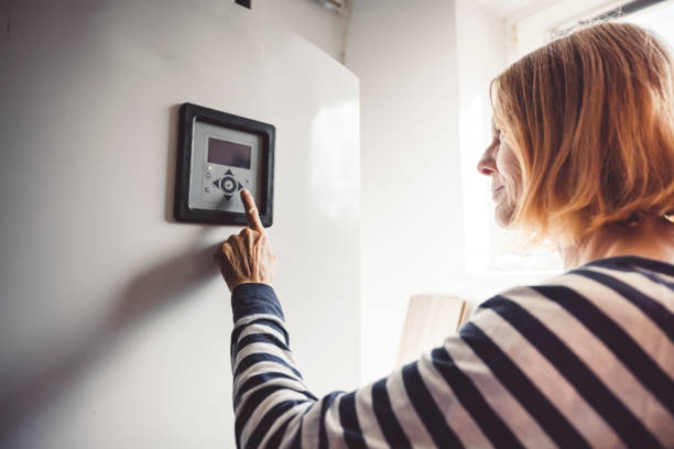 istock Woman changing the settings on the boiler 1278767096