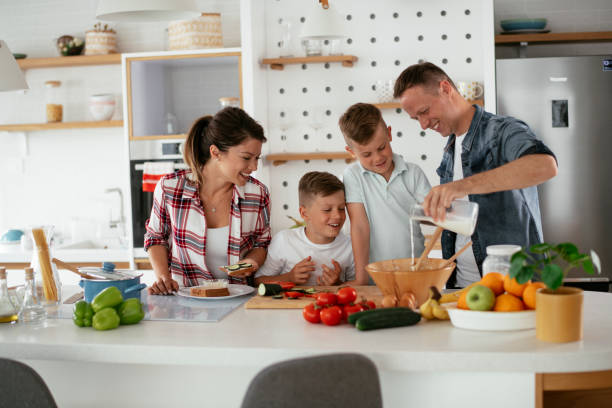 istock Mother and father making breakfast with sons. 1278769353