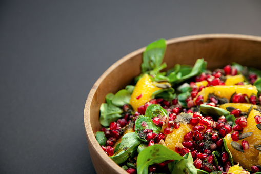 Close-up photography of autumnal salad with lamb´s lettuce, oranges, pomegranates and nuts. Perfectly usable for all autumnal food projects.