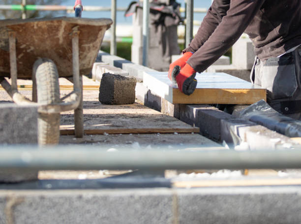 istock Builder preparing and installing insulation within concrete blocks on a residential build with gloves for protection 1278770981