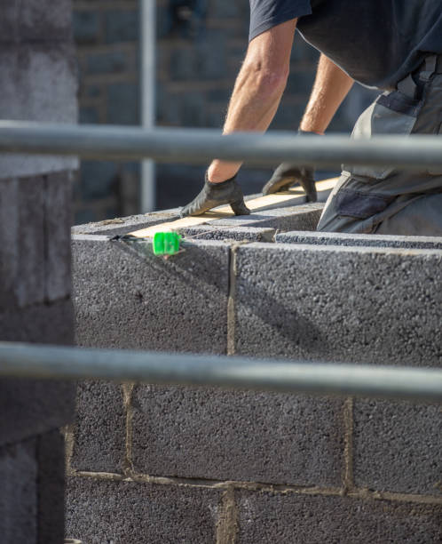 istock Builder preparing and installing insulation within concrete blocks on a residential build with gloves for protection 1278771030