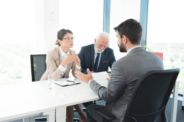 istock Business people interviewing male applicant at office 1278771205