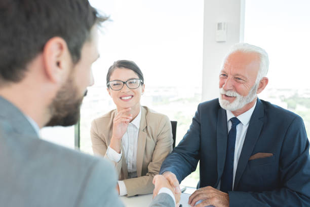 istock Old man congratulating young man on being selected for a job 1278771220