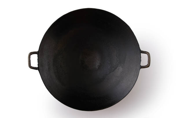 wok de hierro negro vacío sobre fondo blanco - wok fotografías e imágenes de stock