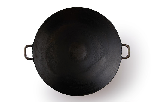 Empty black iron wok on white background