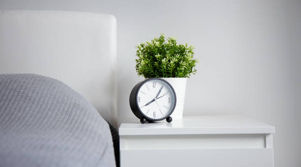 istock good morning concept - alarm clock and houseplant on bedside table 1278774845