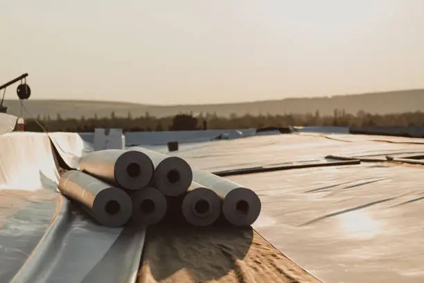 Photo of Roofing PVC membrane in rolls placed on the roof of a hall.Rubber membrane ready.