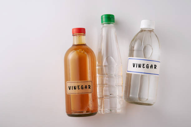 top view two bottles white vinegar and  bottle of apple cider vinegar top view two bottles white vinegar and  bottle of apple cider vinegar vinegar bottle stock pictures, royalty-free photos & images