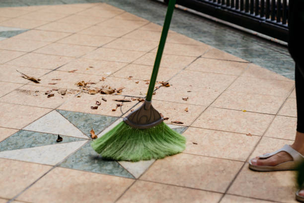 istock Young asian woman sweep and cleaning front yard 1278776615