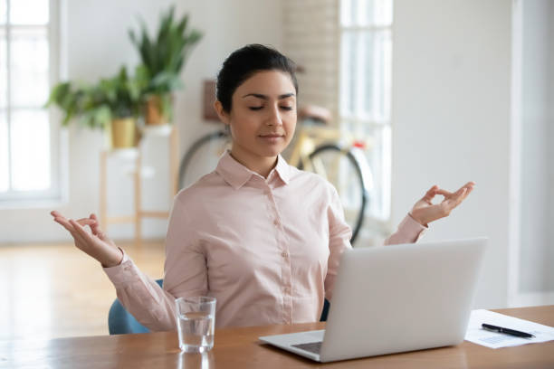 istock Calm young indian woman meditate at workplace 1278778766