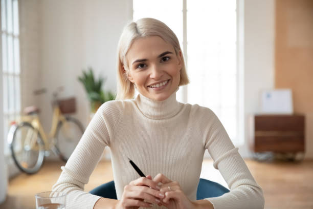 Portrait of smiling Caucasian young woman worker in office Headshot portrait of smiling young Caucasian woman talk on video call at office workplace. Happy motivated female employee or worker have webcam virtual interview or conference. Employment concept. head shoot stock pictures, royalty-free photos & images