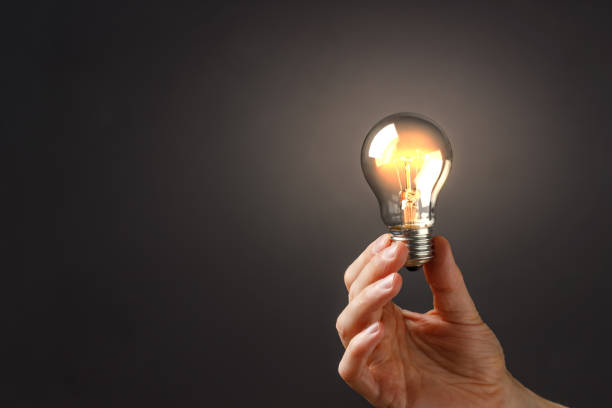 istock A man holds a luminous bulb in his hand. 1278779021