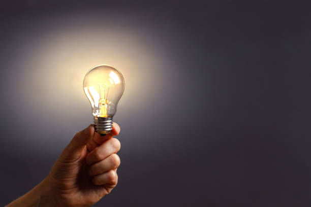 istock A man holds a luminous bulb in his hand. 1278779281
