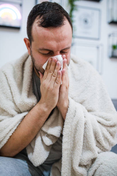 istock Man blowing his nose sick in bed 1278780248