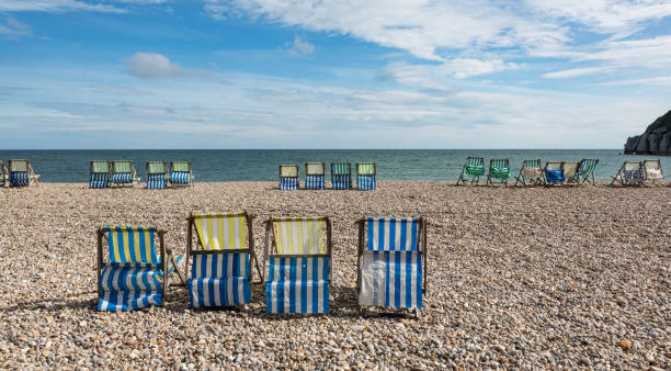 istock Empty deck chairs on the pebble beach of Beer, Devon, UK 1278780433