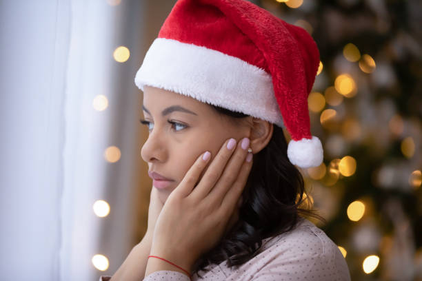 Sad african American woman feel lonely on Christmas day Upset african American young woman in Santa hat look in distance feeling lonely abandoned on winter holidays, sad thoughtful biracial female lost in thoughts celebrate Christmas new year alone pessimism photos stock pictures, royalty-free photos & images