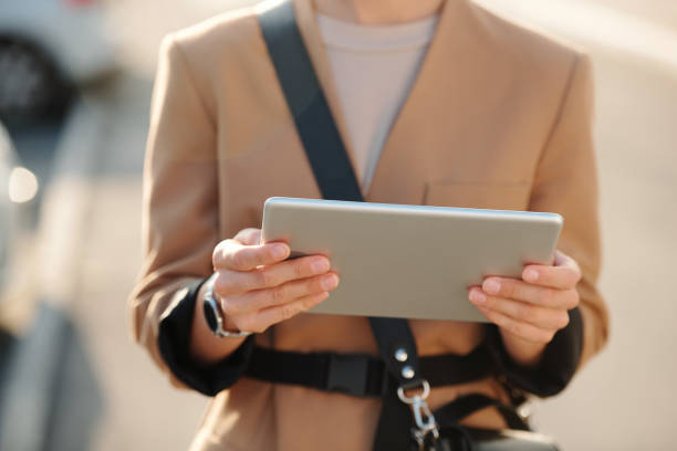 オンラインビデオを見てデジタルタブレットを持つ若いエレガントなビジネスウーマンの手 - digital tablet businesswoman young women watching ストックフォトと画像