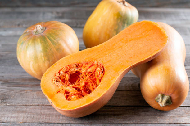 istock Butternut squash sliced in half. Pumpkin, butternut squash pieces on wooden table 1278787913