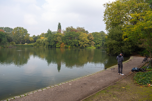 London, UK, United Kingdom- 03 October 2015: Battersea Park in the center of capital town on the river Thames. Angler catching fish.