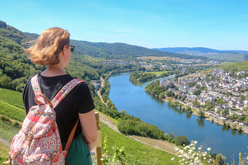 young tourist woman overlooking Moselle river and vineyards near Bernkastel-Kues from Landshut castle