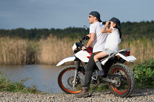 Father and daughter riding a two-seater off-road bike
