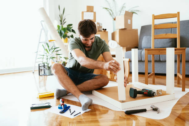 istock Man assemblying furniture after moving into new apartment 1278793766