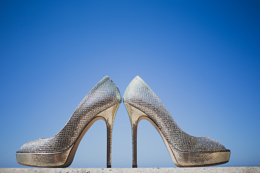 Glamorous silver bridal wedding shoes with backlight, selective focus