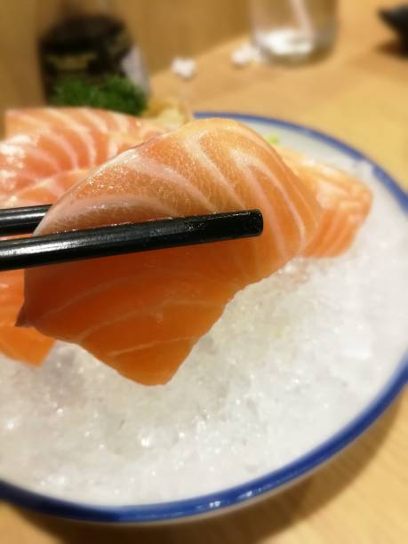 einnahme von lachsfilets mit essstäbchen - vitamin d salmon fillet raw stock-fotos und bilder
