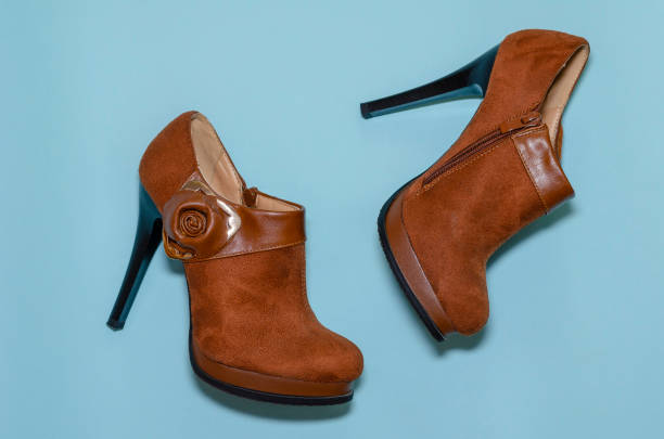 istock Brown women's ankle boots with high heels on a blue background. 1278797838