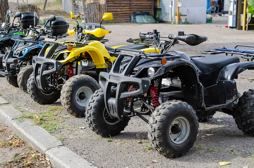 A group of random ATVs in a line outdoors. Rent of transport for off-road trips. Active rest, adventure.