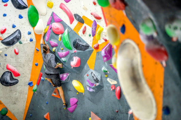 istock Long-haired caucasian man overcoming obstacles on artificial climbing wall. 1278798126