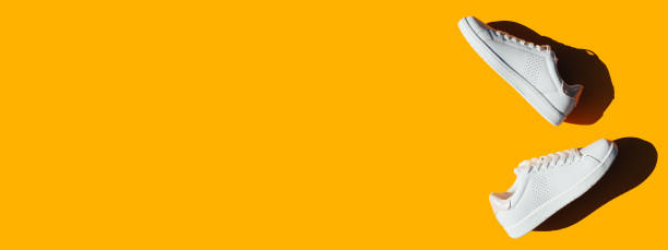 istock Banner with white sneakers on an orange background. 1278798834